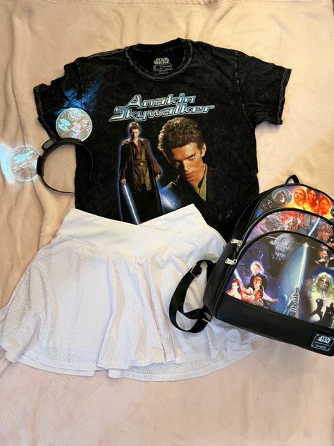 The picture consists of a black tshirt with a picture of Anakin Skywalker with his name written in a blue futuristic font. This is paired with a white skirt and light up Mickey ears that have Star Wars ships on them. Also pictured is a Star Wars Loungefly backpack with scenes from the movies. Disney Tshirt Outfit, Disneybound Aesthetic, Universal Studios Orlando Outfits, Star Wars Tshirt Outfit, Starwars Outfit Ideas, Star Wars Themed Outfits, Star Wars Day Outfit, Star Wars Shirt Outfit, Starwars Outfits For Disney