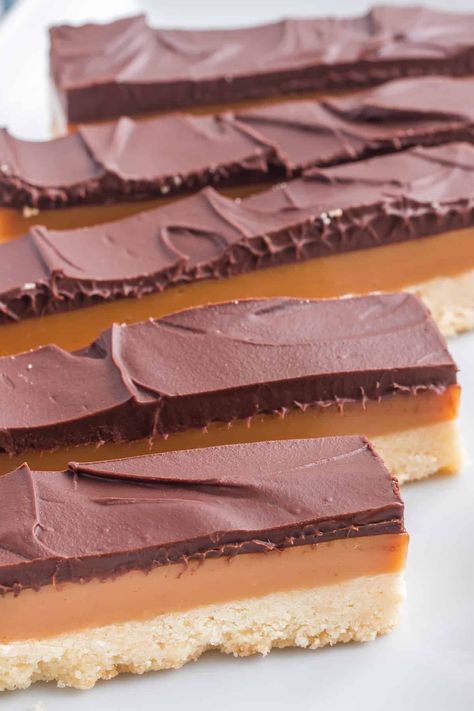 Homemade Millionaire Bars combine layers of buttery shortbread crust, rich caramel, and velvety chocolate. With their irresistible layers of sweetness, they are the epitome of luxury and decadence. Millionaires Bars, Cookies 2023, Millionaire Bars, Homemade Twix Bars, 1950s Food, Twix Bars, Kids Treats, Whipped Shortbread Cookies, Millionaire Shortbread