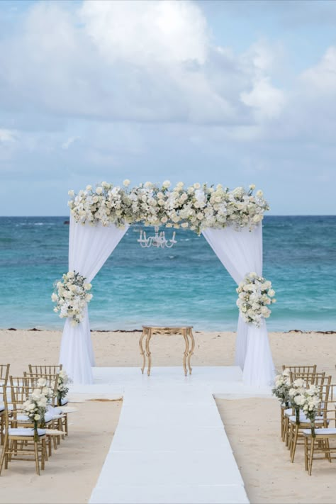 Enchanting wedding ceremony with white gazebo decoration adorned with white roses, orchids, and baby's breath for Terry Lynn and Lance's wedding at Kukua Punta Cana | Dominican Republic | Wedding photography and video by Milan Photo Cine Art #wedding #weddingceremony #weddinggazebo #whitegazebowedding #gazeboweddinginspo #beachwedding #weddingvenue #tropicaldestinationwedding #caribbean #destinationwedding #kukuapuntacana #milanphotocineart #photocineart Beach Wedding Ceremony Arch, White Gazebo, Wedding Gazebo, Beach Wedding Arch, Gazebo Decorations, Sunflower Wedding Decorations, Dominican Republic Wedding, Romantic Beach Wedding, Destination Wedding Decor