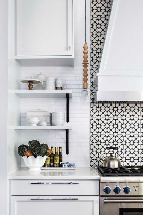 Gorgeous black and white mosaic cooktop tiles are positioned behind a white wood clad hood mounted above a stainless steel oven range.  Deco Cuban Star tiles from www.decobella.co.za Accent Tile Behind Stove, Tile Behind Stove, Tiles Black And White, Black And White Backsplash, White Stove, Contemporary Style Kitchen, Stove Backsplash, Black Mosaic, Kitchen Backsplash Designs