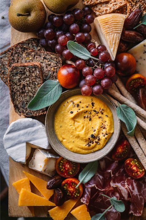 Fall in love with snacking again! This Colorful Autumn Chacuterie Board is your new go-to for fall gatherings and wine pairing nights. Packed with rich cheeses, dried meats, and homemade hummus, it's the ultimate meeting of flavors and colors. Level up your food styling game with our platter styling tips and tricks! Try the recipe now! Autumn Snack Board, Fall Cheese Platter Ideas, Fall Hummus Platter, Autumn Cheese Board, Fall Harvest Charcuterie Board, Fall Hummus, Entertaining Dinner, Pumpkin Hummus, Thanksgiving Entertaining