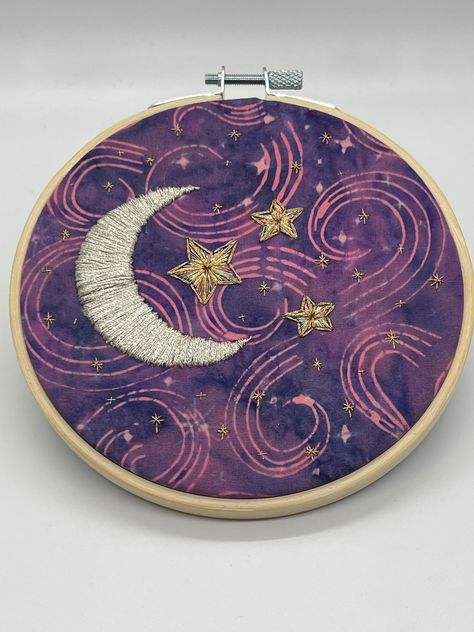 This is a five inch hand embroidered piece. It was stitched on Batik fabric using metallic thread.  The back is finished with a piece of felt. Embroidery Decor, Ravenclaw Aesthetic, Purple Moon, Simple Hand Embroidery Patterns, Sky Stars, Handmade Embroidery Designs, Stars Moon, Star Embroidery, Flower Embroidery Designs