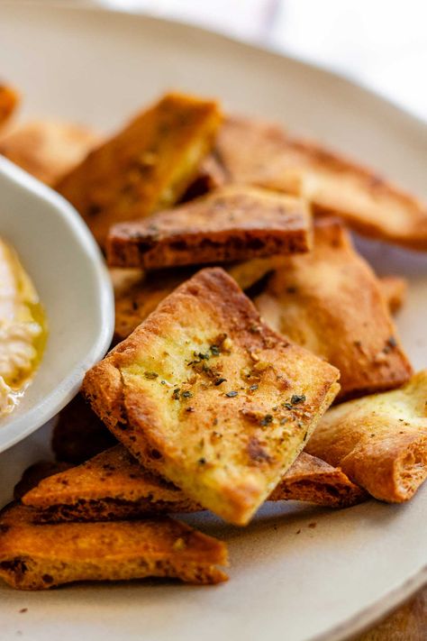 Craving a crunchy snack? Try these homemade air fryer pita chips! Made with just a few ingredients, they're crispy, flavorful, and ready in minutes. Use them to scoop up dips, crumble over salads, or munch on their own. The za'atar seasoning adds a unique taste, but feel free to experiment with your favorite spices. Perfect for using up leftover pitas too! Pita Crisps Recipe, Crispy Pita Chips, Air Fryer Pita Chips, Pita Chips Baked, Pita Chips Air Fryer, Chips Air Fryer, Pita Chips Recipe, Homemade Pita Bread, Popcorn Treat