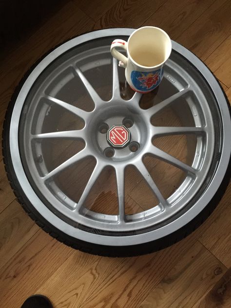 New coffee table made from an old car wheel and tyre, sprayed silver and fitted with a 5mm clear Acrylic top Car Rim Coffee Table, Workshop Cafe, Wheel Table, Rat Rod Cars, Car Wheels Diy, Garage Car, Wheel Craft, Camaro Car, Car Part Furniture