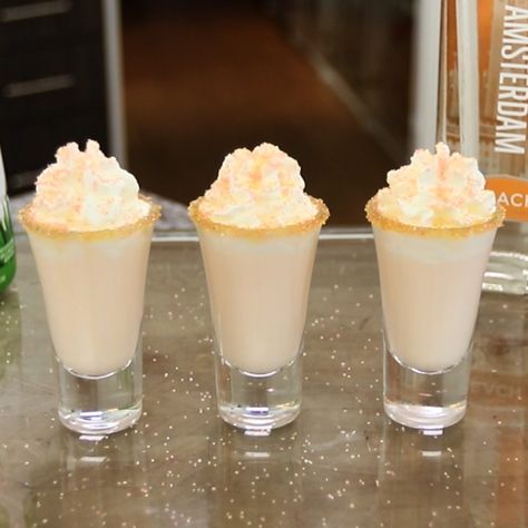 Dessert shooters absolutely do not get better than these Peaches And Cream Shots. These perfect little peach vodka cocktail shots combine peach vodka, peaches n' cream rum, and half & half, and is garnished with orange sugar, and whipped cream for extra peach dessert love. Peach Cocktail Recipe, Fruity Shots, Birthday Cake Shots, Shots Alcohol Recipes, Shooter Recipes, Cake Shots, Peach Vodka, Peach Cocktail, Dessert Shots