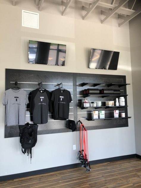 This display takes up a good amount of wall space, but still leaves room above and below for other props and fixtures to be placed around it. Slate Wall Display Retail, Merchandise Wall Display Ideas, Merch Wall Display, Retail Wall Display Ideas, Product Display Wall, Retail Wall Displays, Physio Clinic, Slat Wall Display, Retail Ideas