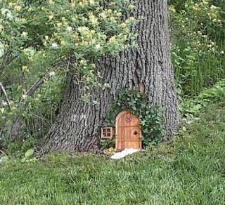 This one is very ornate, vines growing around the door and and even has a  tiny window. Tiny Window, Fairy Garden Doors, Fairy Tree Houses, Fairy Garden Designs, Budget Garden, Faeries Gardens, Fairy Tree, Gnome House, Fairy Garden Houses