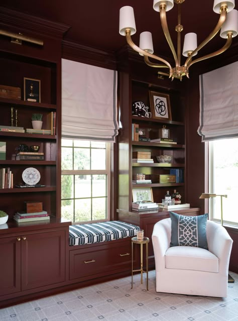 A dark and moody office featuring maroon cabinets and sophisticated library lights creating a refined work environment.   Design by Amy Kummer Interiors  Photography by Michael Hunter Photography Den Office Combo With Tv, Moody Office Built In Desk, Craftsman Office Ideas, Traditional Conference Room, Gentleman’s Library, London Home Office, Cluttered Office Aesthetic, Maroon Office Walls, Moody Office Built Ins