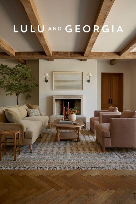 Living room featuring a beige English style sofa opposite of two light pink accent chairs with a light wood coffee table separating them. A fireplace and high ceiling with beams sets the tone for this California English inspired living space. English Style Living Room, Earthy Living Room, Stylish Living Room, Room Remodeling, Living Room Inspo, Decor Living Room, Ideas Home, Dream Home Design, Living Room Inspiration