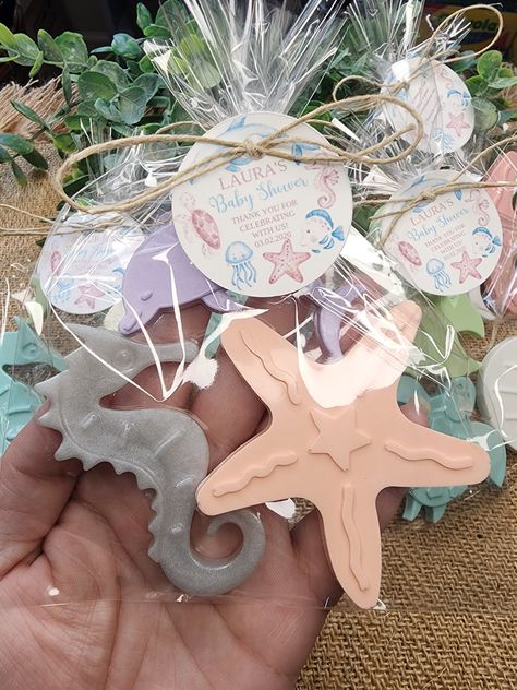 Make a splash at your baby shower with our adorable under the sea soap favors! These handmade soap bars are gentle on the skin and feature a light, fresh scent that everyone will love.  You can choose from the list of scents available and we can make them in any color. Each favor comes with 3 soaps packed in a cellophane bag tied with twine and a personalized tag. The gender-neutral design is perfect for any shower, while the ocean-themed packaging adds a fun and playful touch. Your guests will Sea Baby Shower Theme, Baby Shower Soap Favors, Beach Soap, Ocean Baby Showers, Beach Baby Showers, Soap Packing, Sea Baby Shower, Mermaid Baby Showers, Handmade Soap Bar