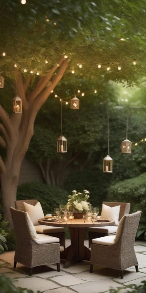 Design an intimate patio dining area beneath a canopy of trees for a natural and romantic setting. Place a round table surrounded by cushioned chairs, allowing the dappled sunlight to filter through the foliage. Hang fairy lights or lanterns in the trees to create a magical atmosphere, and use earthy tones in the decor for a harmonious blend with nature. This secluded tree canopy oasis offers a serene and private space for a romantic meal in the midst of the outdoors. Small Outdoor Dining Ideas, Picnic Table Under Tree, Outside Dining Area Ideas, Fairy Lights Outdoor Patio, Patio Under Tree, Sitting Area Under Tree, Under Tree Ideas, Small Outdoor Dining Area, Backyard Table Decor