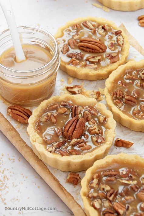 Up your pecan pie game with easy pecan tartlets! Mini pecan tarts consist of a delicious buttery brown sugar crust with a caramel-like maple toffee filling and crunchy pecans. Maple syrup and pecans are heavenly pairing. It’s easily my favorite fall baking recipe because they look cute and taste so darn delicious. This little pecan pie recipe is the perfect fall treat and small Thanksgiving dessert! Includes a chocolate variation, made without cream cheese or bourbon. | CountryHillCottage.com Mini Pecan Tarts, Pecan Pie Squares, Pecan Tartlets, Cinnamon Dessert Recipes, Pecan Pie Cake Recipe, Pecan Tarts Mini, Pie Cake Recipe, Pecan Tarts Recipe, Pecan Pie Tarts