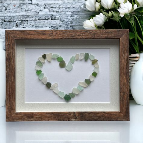 This is a great sea glass picture of a mosaic mixed greens and white heart. The sea glass was found on the beaches on the North Shore of Massachusetts. They are set on an acid free paper. The picture is framed in a shadowbox washed wood frame with a glass front that can hang or stand with a glass front. The sea glass in the picture you receive may vary from the ones in the photograph but will be similar in color and size. The mat and the frame will be the same as the photograph. Total Dimensions Glass Shadow Box, Rock Pictures, Sea Glass Artwork, Sea Glass Green, Sea Glass Art Diy, Sea Glass Mosaic, Sea Glass Art Projects, Mosaic Heart, Beach Glass Crafts