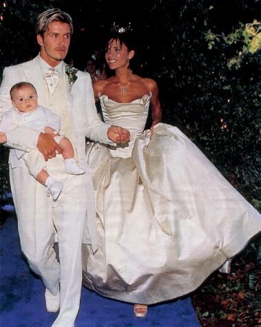 July 4, 1999: David and Victoria Beckham were already big stars when they wed at 16th Century Luttrellstown Castle near Dublin. Victoria wore Vera Wang, Becks wore ivory and cream for the ceremony, but changed into purple for the reception after the couple's infant son Brooklyn threw up on him. Footballer Gary Neville served as best man, and all four Spice Girls were in attendance. An 18pc. orchestra entertained a black-and-white reception, and the couple donated their 5-tier cake to charity. Victoria Beckham Wedding Dress, Victoria Beckham Wedding, Beckham Wedding, Celebrity Wedding Photos, Posh And Becks, 16th Wedding Anniversary, Victoria And David, Celebrity Bride, Vera Wang Wedding