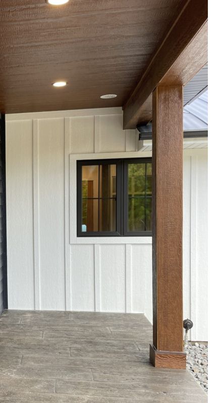 Stained Wood Trim Exterior, Cedar Porch Columns, Wood Wrapped Columns Front Porch, White House Brown Columns, Best Stain For Porch Columns, Porch Posts Ideas, White Farmhouse With Stained Columns, Stained Porch Columns Cedar, Cedar Posts Front Porch Gray House