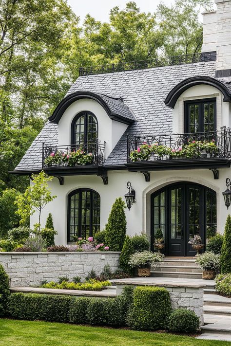 French white cottage with grey stone tile roof with dormers iron balconies with flowers stone brick foundations front yard with steps geometric. Ever wondered how white exterior houses manage to look both timeless and incredibly chic? White Brick Mansion, Cottage Vibe House Exterior, Tudor Mansion Exterior, White Exterior Homes, Modern Victorian House Exterior, Stone Roof, Industrial Style House, French Homes, Villa Exterior Design