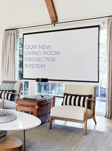 Living room projector system with screen mounted in front of large window Tv Solutions Living Room, Projector Screen Living Room, Tv Solutions, Room Projector, Projector Wall, Hidden Projector, Motor Homes, Projection Screen, Emily Henderson