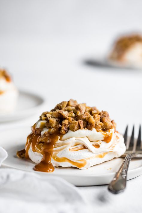 Soft and pillowy caramel swirled mini pavlova cakes with cheesecake mousse, salted caramel sauce, and chopped glazed walnuts. Impress everyone with these meringue cakes that are super easy to make, while seeming decadent and sophisticated! #pavlova #meringue #saltedcaramel #smallbatch #glutenfree #caramel #cheesecake #nobake #valentinesday Pavlova Toppings, Chocolate Pavlova, Pavlova Dessert, Glazed Walnuts, Pavlova Cake, Mini Pavlova, Meringue Desserts, Salted Caramel Cheesecake, Cheesecake Mini