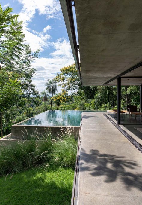 A modern house that has an infinity edge swimming pool that wraps around the corner. Raised Pools, Tall Grasses, Modern Outdoor Spaces, Ultra Modern Homes, Infinity Edge Pool, Concrete Pool, Rooftop Patio, Rooftop Deck, Garden Pool