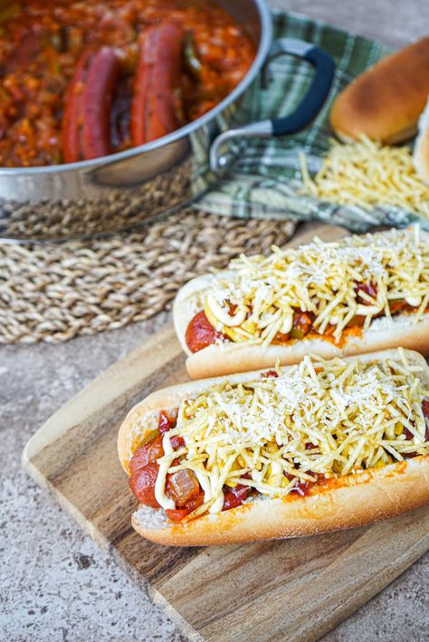 Close up of Cachorro Quente (Brazilian Hot Dog) on a wooden board with shoestring potatoes and Parmesan cheese. Shoestring Potatoes, Hod Dog, Greasy Food, International Food, I Want To Eat, Food Crafts, Parmesan Cheese, Hot Meals, Wooden Board