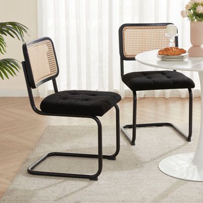 This 2-piece dining chair set blends mid-century modern design with natural elements, making it a great choice for your beach-inspired dining space. Each chair features a sleek cantilever steel frame in a matte black or silver finish, providing a floating sensation as you sit. The backrest is crafted from natural rattan for a breezy and breathable design on hot days. For added comfort, the seat cushions are filled with high-density foam and upholstered in textured boucle fabric, ensuring you won Dining Chairs Wood, Rustic Dining Chairs, Cantilever Dining Chair, Black Dining Room, Metal Fabric, Rattan Dining Chairs, Chairs Dining, Mid Century Modern Chair, Rattan Chair