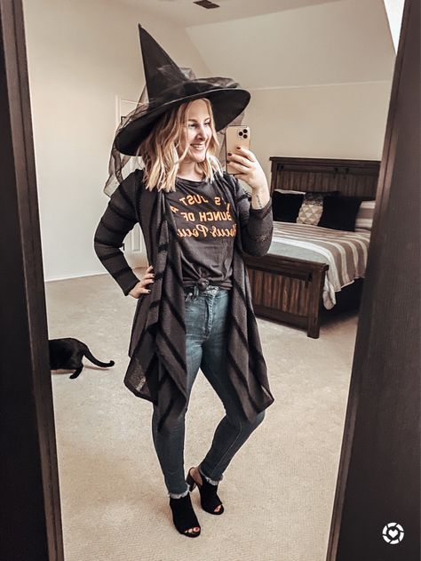 Easy last-minute witch costume idea using clothes from your closet! Pair any Halloween graphic tee with a black open front cardigan, frayed hem jeans and open-toe mule heels, then top with a witch hat for a chic, festive and fashionable costume! 🖤 | La Vida Lati Modest Witch Costume, Good Witch Costume For Women, Western Witch Costume, Mom Witch Costume Diy, Witches Customes, Cute Witch Costume For Women Diy, Work Appropriate Witch Costumes, Modern Witch Costume Diy, Easy Witch Outfit