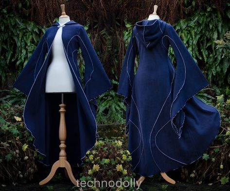 ~ Haunted Hawtin Cloak ~ Made to Measure ~ The floor length Haunted Hawtin Cloak is a simple & beautiful design. Made using soft fleece fabric with elegant trim detail to create a delicate flowing line of colour & form. It is floor length with large medieval flared sleeves, a open front with a single clasp fastening at the throat & rounded hood. Colours used in photos: Midnight Blue with Silver Grey detail. *From Petite Pixies to Rubenesque Goddesses. Whatever shape you take I can ac Fantasy Clothing Inspiration, Space Cloak, Blue Fantasy Outfit, Dark Blue Cloak, Cloak With Sleeves, Dragon Cloak, Hooded Cloak Pattern, Long Blue Coat, Cloak Fashion