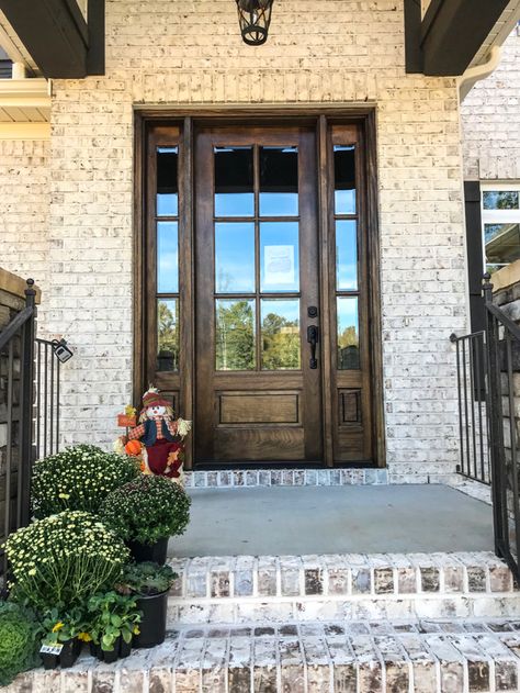 White brick, dark trim and stone set this Parade Home apart Exterior Brick Treatments, Light Brick With Dark Trim Exterior, Aspen Ridge Brick, Brick Around Front Door, White House Dark Brown Trim Exterior, Taupe And Black House Exterior, Light Brick House Exterior Dark Trim, Brick Ideas For House Exterior, Southern Brick Homes