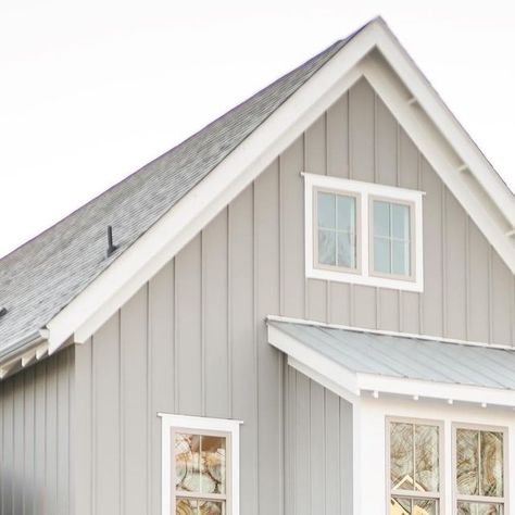 McNeill Burbank on Instagram: "Galvanized metal. Clay windows. Board & batten. A fresh perspective on the tenacious modern farmhouse. An architectural style that remains timeless yet relevant with details that universally feel familiar, peaceful and nostalgic. Home feat. is our award-winning Heritage home completed in the charismatically charming town of Carrboro, North Carolina. The Heritage is currently archived in our portfolio. Similar plans are available to design & build. Visit our site for details – link in bio. Dorian Gray SW 7017 (B&B) Eider White SW 7014 (Siding, Trim)" Board And Batten Metal Siding Colors, Board And Batten Siding With White Windows, Cream Board And Batten Exterior, Gray Board And Batten Exterior, Metal Siding Colors, Apartment Bathrooms, Eider White, Exterior House Siding, Board And Batten Exterior