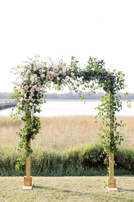 This gorgeous arbor decorated with florals and greenery makes for the perfect wedding altar! #weddingarbor #arborwithflorals #arborwithgreenery #lowndesgrovewedding #lowndesgrove #charlestonwedding #peperevents Greenery On Arbor Wedding, Rectangle Floral Arch Wedding, Arch’s For Weddings, Garden Party Wedding Arbor, Smilax Wedding Arch, Square Arch Wedding Flowers, Wedding Floral Arbor, Spring Arch Wedding, Arbor Flower Arrangements