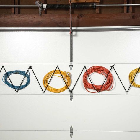 Garage Door Extension Cord Storage.  Ever wish you had one more garage wall to hang stuff on? Well, you do. Your garage door is a perfect place to store lightweight items like extension cords. (Yes, they'll stay put when the door opens and closes.) Install screw eyes diagonally about 8 in. apart and thread bungee cords (with the ends cut off) through them. Now you have a perfect bungee “corral” to hold your extra extension cords. Stuff Storage, Clever Storage Ideas, Garage Hooks, Fishing Rod Storage, Garage Organize, Garage Remodel, Extension Cords, Garage Shed, Bungee Cords