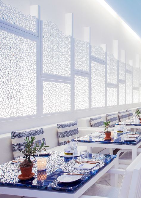 Blue and White Dining Table and decor at Atlantikos Greek Restaurant White Restaurant Interior, Blue And White Restaurant Design, White Restaurant Design, Modern Greek Decor, Greek Dining Table, Greek Cafe Design, Greek Restaurant Interior Design, Modern Greek Restaurant, Greek Cafe Interior Design