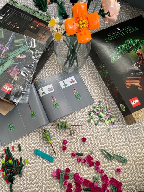 lego kits, building instructions, and legos sprawled out on a   rug with flowers in a glass vase Making Lego Aesthetic, Lego Instagram Story, Lego Night, Lego Dates Ideas, Lego Picnic, Lego Date Night, Lego Dates Aesthetic, Aesthetic Lego, Lego Date