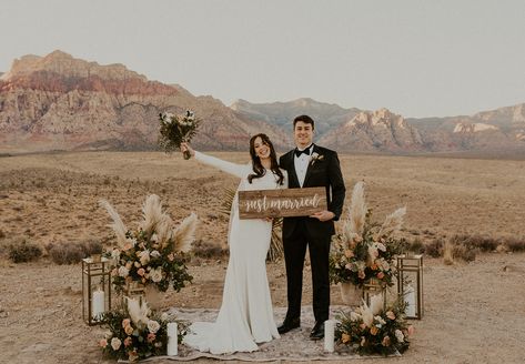 This elopement ceremony at red rock canyon in las vegas, nevada had the most beautiful ceremony decor! The desert backdrop with the red rock mountains, the rug, candles, and lanterns, and the boho flowers and pampas grass on each side of the altar was a gorgoues setting for an elopement. Teh couple held a sign that said just married to announce their elopement! www.elopementlasvegas.com #redrockcanyon #lasvegaswedding #microwedding #elopementpackage #elopement hotzel photography Sandy Landscape, Desert Wedding Decor, Nelson Ghost Town Wedding, Nelson Ghost Town, Vegas Wedding Venue, Las Vegas Wedding Venue, Outdoor Elopement, Timeless Wedding Dress, Vegas Elopement