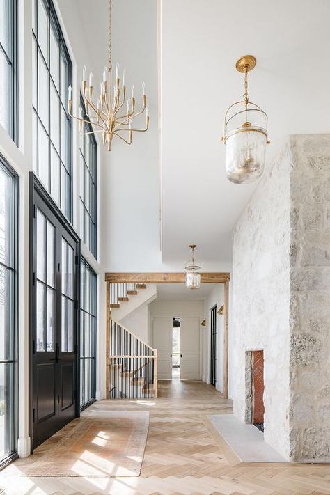 Cottage style foyer features a tall rustic gray stone fireplace and blond herringbone wood floors, illuminated by a mercury glass lantern. Brick Herringbone Floor, Grey Stone Fireplace, Reclaimed Beams, Kate Marker Interiors, Reclaimed Wood Floors, Herringbone Wood Floor, Herringbone Wood, Rustic Backdrop, Decor Studio