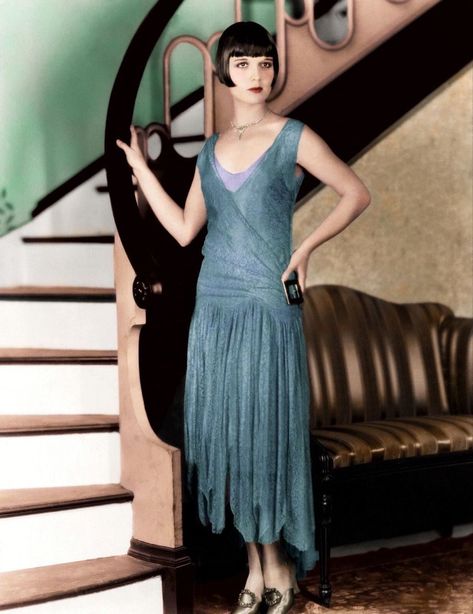 Louise Brooks 1927 colorized in blue hi-low handkerchief hem Flapper dress with fabulous side buckle and matching Pilgrim buckle pumps. Her bob is perfection as are her eyes and the lips that excited a generation. Louise’s long legs and short body made her look much taller than her 5’2” height. 1920s Lace Dress, Louise Brooks 1920s, 1920s Movies, 1920s Evening Gowns, 20’s Fashion, Style Année 20, 1920s Outfits, Hollywood Costume, 1920 Fashion