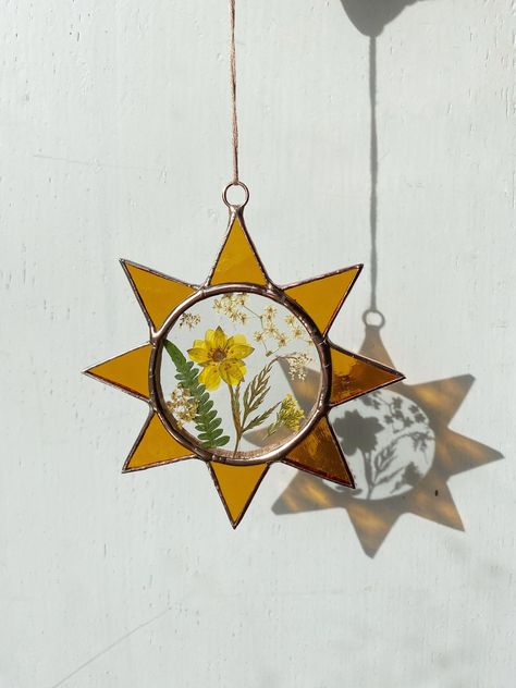 A beautiful and unique hand made stained glass sun catcher with English pressed flowers and amber glass.    Hang the frame up on a wall, in a window or mix and match different flower frames to make a feature wall in your home The frame is shown finished with a shiny copper patina and made using only lead free solder.  Measures - H 11cm  X L 10.5cm X W 4mm Stained Glass With Dried Flowers, Scrap Stained Glass Projects, Stained Glass Workshop Ideas, Simple Stained Glass Designs, Stained Glass Picture Frames, Stained Glass Aesthetic, Stained Glass Wood, Sun Decor, Stained Glass Hanging