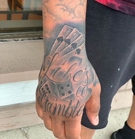 Life’s A Gamble Tattoo Design Hand, Life’s A Gamble Hand Tattoo, Lifes A Gamble Tattoos, Hand Tattoos For Black Men, Life Is A Gamble Tattoo, Trap Tattoos Men, Gambling Tattoo Ideas, Lifes A Gamble Tattoo, Hand Tattoos Men