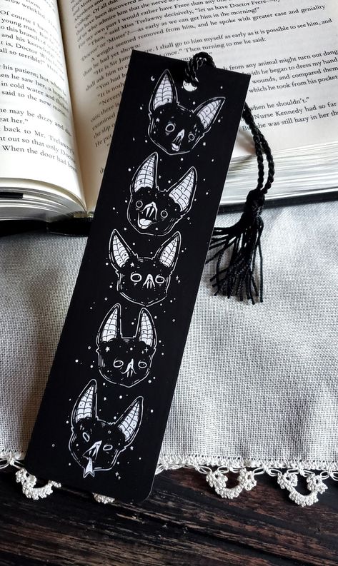 "Spooky and cute, these vampire bats with adorable and kooky expressions will haunt your book and hold your place with this handcrafted bookmark. This bookmark is laminated on both sides, with new sugar frosted magical sparkle lamination on the front (fear not it does not shed any glitter, and looks matte sometimes under low light) and soft touch matte on the back. Adorned with a tassel, this cute goth bat bookmark makes a great gift for your favorite spooky book lover. Check out my other listin Bat Bookmark, Goth Bookmark, Spooky Bookmarks, Vampire Bats, Homemade Bookmarks, Black Vampire, Tears Art, Homeschool Crafts, Creative Bookmarks