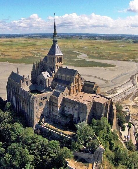 The abbey church that towers over the island has an imposing 11th-and 12th-c. Romanesque nave and an elegant choir in Flamboyant Gothic style (built 1450-1521). The tower and spire, crowned by a statue of St.Michael, were added in the 19th cent. The church is built over three crypts,the oldest dating probably from Carolingian times (8th-10th century). Flamboyant Gothic, Mt St Michel, Mont Saint Michel France, France Landscape, Medieval Fair, Mont St Michel, Religious Architecture, Photography Tools, Cathedral Church