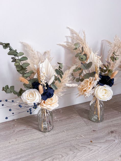 Small vase centrepieces consisting of dried, preserved and artificial flowers. The perfect keepsake from your wedding day and also great gifts for your wedding party! These are totally customisable so if you're looking for a different colour from the main listing (navy blue and sage) please write in the personalisation box 😊 The size of the vase is 14x7.5cm and the total size of the vase and florals is around 40x25cm (sizes may vary). Please note, the price is for one vase centrepiece. For more designs please follow me on Instagram - boho_backdrops Thank you. Kerris x Blue Eucalyptus Wedding Centerpiece, Simple Cheap Centerpieces Wedding, Rustic Wedding Decor Navy Blue, Blue Eucalyptus Centerpiece, Navy Blue Wedding Centerpieces Diy, Navy Blue Table Decorations, Wedding Beach Centerpieces, Dusty Blue And Sage Green Centerpieces, Sage Green And Navy Blue Wedding Bouquets