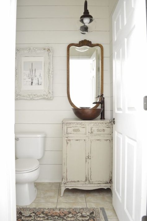 To achieve a stylish farmhouse decor, this bathroom uses a copper schoolhouse light, white shiplap, and a repurposed cabinet as a vanity. Powder Room Reno, Diy Faux Brick Wall, Powder Room Renovation, Pretty Bathroom, Barn Light Electric, Vintage Porch, Cheap Ideas, Faux Brick Walls, Diy Bathroom Storage