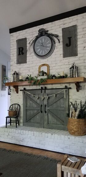 Hubby took my idea and made these, removable, barn doors to hide our original glass fireplace doors. They are meant for show only and do not slide. They lift off, easily, when we decide to use the fireplace in cold weather. They co-oridinate perfectly with the original ones, that he made for the door and windows, on the opposite side of the living room.I'm so happy and proud of his talent and patience... it was a bit of a challenge getting it customized, but we did it! Fireplace b… Fireplace Farmhouse Doors, Barn Doors Over Windows, Barn Doors Fireplace Cover, Unused Fireplace Ideas Brick, Barndoor Fireplace Cover, Diy Fireplace Doors, Barn Doors For Fireplace, Fireplace Barn Doors Ideas, Bar Doors In The House