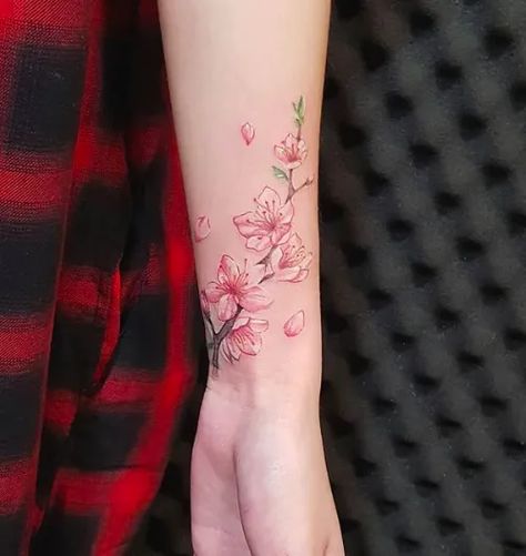 10+ Cherry blossom branch tattoo ideas for your new floral tattoo design! Check out our blog to read about different meanings, history and ideas for #cherryblossomtattoos! #tattoostylist #tattooideas #cherryblossom #floraltattoo Wrist Cherry Blossom Tattoo, Cherry Blossom Wrist Tattoo For Women, Cherry Blossom Tattoo Meaning For Women, Tattoo Ideas Cherry Blossoms, Cherry Blossom Tattoo Forearm, Cherry Blossom Wrist Tattoo, Cherry Blossom Branch Tattoo Arm, Cherry Blossom Tattoo Wrap Around Wrist, New Tattoos For Women