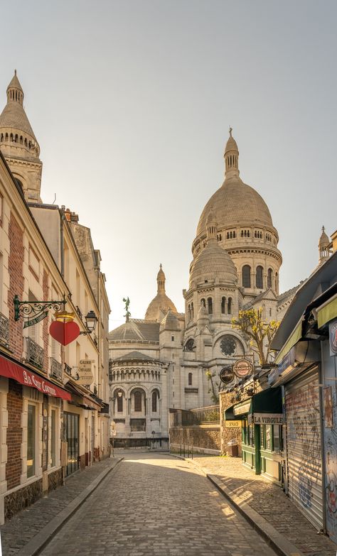 Here's the Montmartre shortly after sunrise. A walk in Montmartre is a must if you really want to enjoy this small Parisian village. Take some time to walk around its streets before maybe having a coffee and a croissant to start your day in Paris.  #paris #travel #photography #aesthetic #ambiance Paris France Architecture, Paris Destinations, France Street Photography, Streets In Paris, Monmarte Paris Aesthetic, Sacre Couer Paris Aesthetic, Montmartre Paris Photography, Paris City Aesthetic, Day In Paris