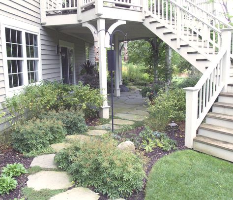 Under Porch Landscaping Ideas, Under Stairs Garden Outdoor, Bottom Of Deck Stairs Landing, Landscaping Walkout Basement, Under Deck Stairs Ideas, Under Deck Patio Ideas Walkout Basement, Walkout Basement Patio Ideas Under Decks, Walk Out Basement Landscaping, Under Deck Landscaping Ideas