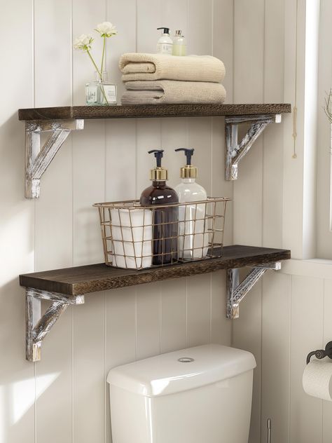 PRICES MAY VARY. This floating shelf set is constructed of durable paulownia wood, featuring a natural wood texture, lightweight, and wear-resistant The wall shelf comes with all necessary mounting accessories, making installation a breeze. Adjust the triangular support position as needed Measuring size: 24*6*6.5 inch, which can effectively expand your storage space. 0.8in thickness plate is not easy to deform and warping Carbonized black plate and whitewashed bracket, a fusion of the rustic and Wood Shelf Bathroom, Small Rustic Bathroom Ideas, Small Bathroom Shelves, Bathroom Wood Shelves, Dark Wood Bathroom, Shelves Over Toilet, Bathroom Shelves Over Toilet, Shelves For Wall, Toilet Shelves