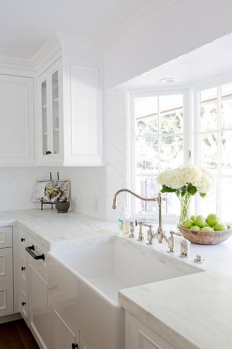 A gorgeous farmhouse sink is paired with an antique polished nickel faucet mounted in front of a bay window to a honed white marble countertop accenting white cabinets adorning oil rubbed bronze hardware. Kitchen Sink Decor, Kitchen Cabinets Decor, Classic Kitchen, Marble Counter, White Marble Countertops, White Kitchen Design, Farmhouse Sink Kitchen, Kitchen Farmhouse, Kitchen Marble