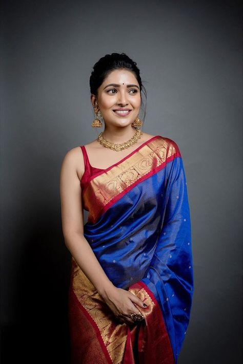 In a elegant dark blue color pattu / kanjeevaram saree, red color sleeveless blouse design, necklace and jewelry Vani Bhojan, Sleeveless Blouse Designs, Saree Wearing Styles, Indian Sari Dress, Indian Saree Blouses Designs, Indian Fashion Saree, Traditional Indian Outfits, Indian Woman, Saree Blouse Designs Latest