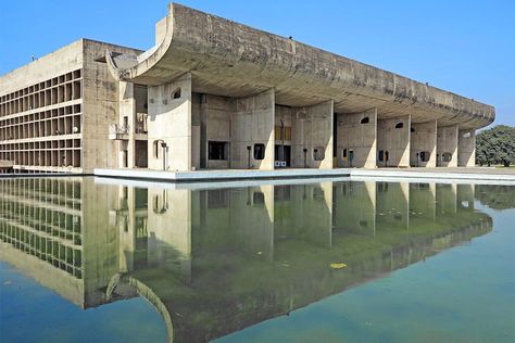 Chandigarh, the utopian city designed by Le Corbusier with Pierre Jeanneret in 1947, in post-independence India, was built largely out of concrete. In the Palais de l’Assemblée, situated on a reflecting pool, the swooping sculptural form at the entrance contrasts with the building’s linear concrete columns throughout. Le Corbusier Chandigarh, Brutalist Interior, Corbusier Architecture, Le Corbusier Architecture, Villa Savoye, Concrete Buildings, Famous Architecture, Genius Loci, Walter Gropius